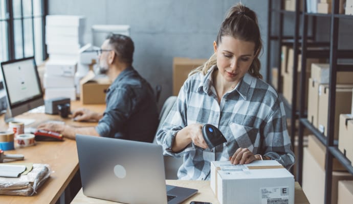 Persoană care tastează pe un laptop așezat pe o pernă