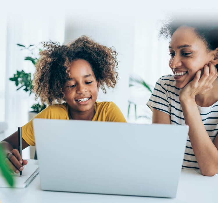 Mamă și fiică folosind laptopul pentru a lansa Norton Family.